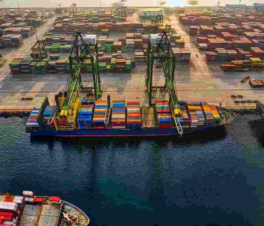 A boat at a dock loaded with shipping containers