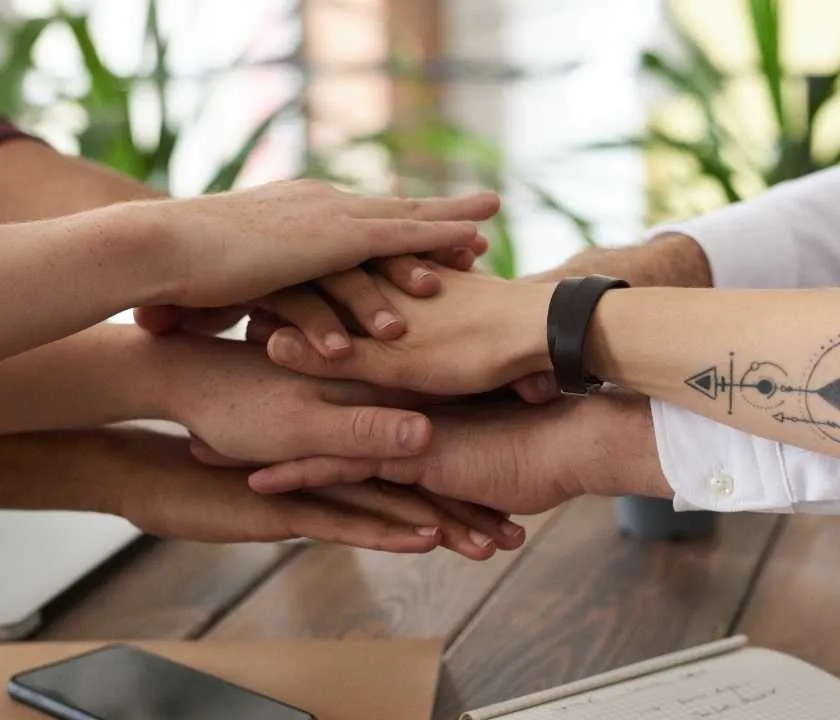 A collection of hands on top of each other, symbolising teamwork